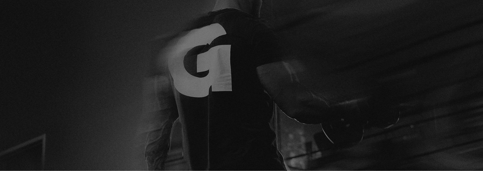 Dark gym backdrop with a faded G emblem
